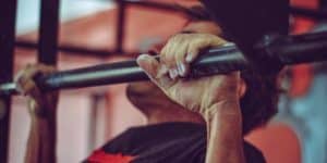 A man doing pull ups on a CrossFit style pull up bar.