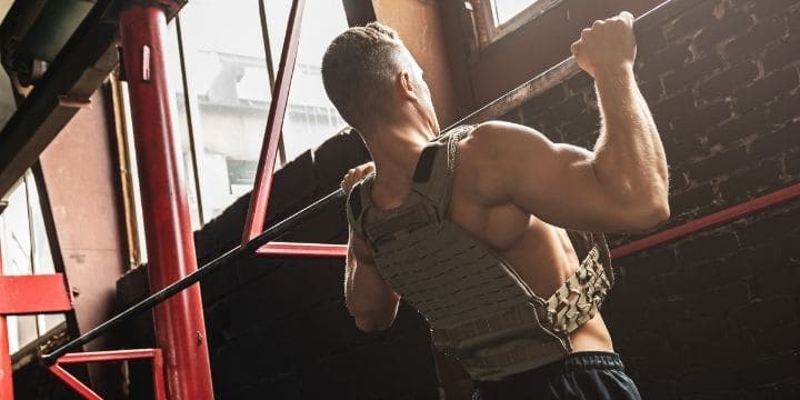 A man doing pull ups on a pull up bar.