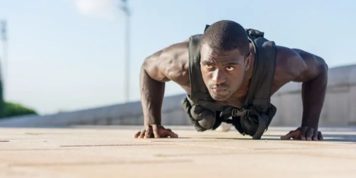 A man doing weighted vest push ups.