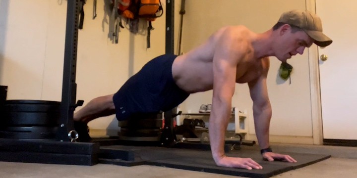 The author of Lunch Break Fitness doing push ups in his minimalist garage gym.