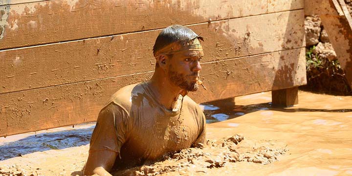The author of Lunch Break Fitness in a Spartan Race mud obstacle.
