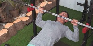 A lifter doing inverted rows using a barbell.