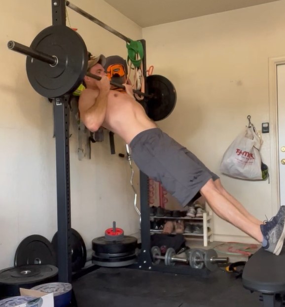 The ending position of a jackknife chin-up, with a supinated grip.