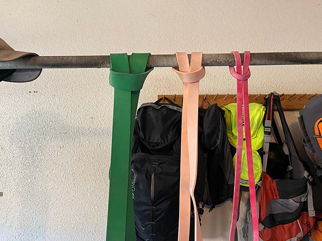 Three resistance bands hung over a pull-up bar.